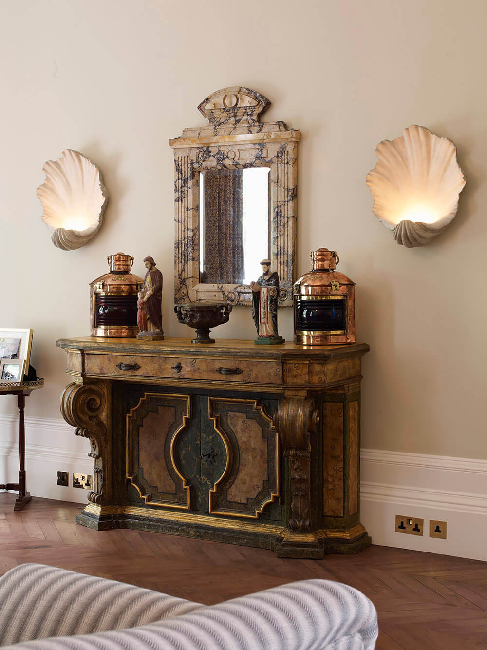 Luxury interior of Notting Hill house with shell-shaped lights and antique sideboard.