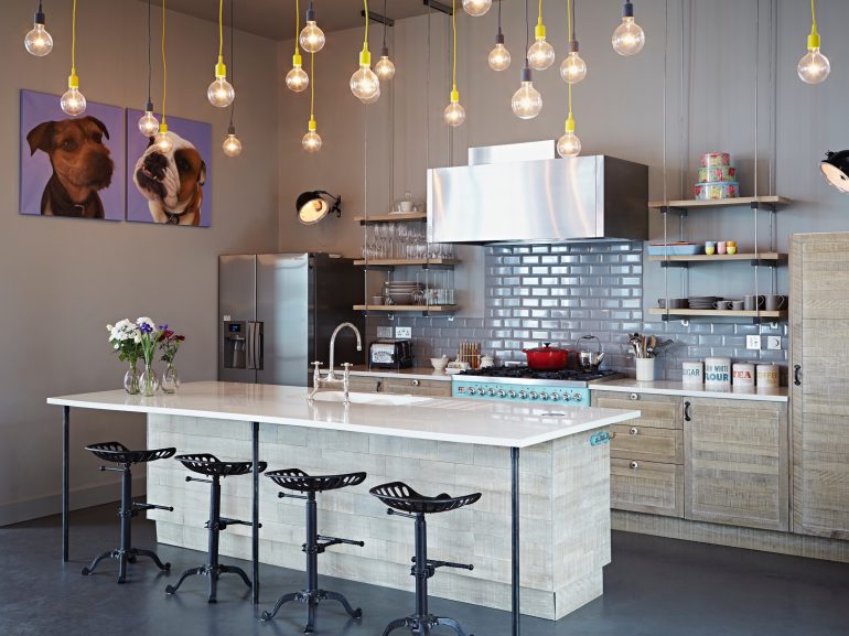 Lake District family house kitchen with modern pendant lights and colourful artworks of dogs on the walls.