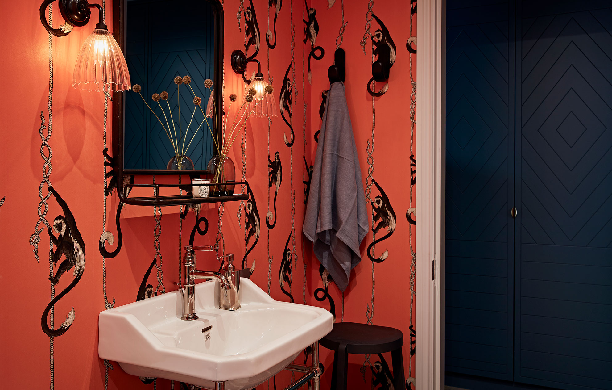 Queens Park bathroom sink with unusual red wallpaper and matte black doors