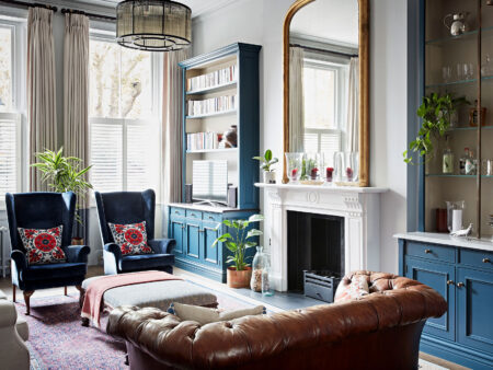 Bespoke interior design of London home with blue cupboards and armchairs.