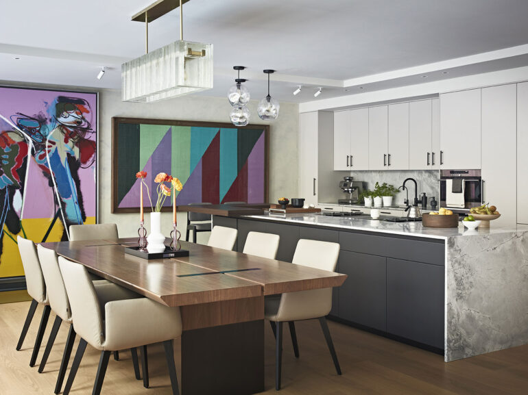 Luxury kitchen and dining room interior design in Notting Hill West London with a marble kitchen counter and colourful artworks on the wall.