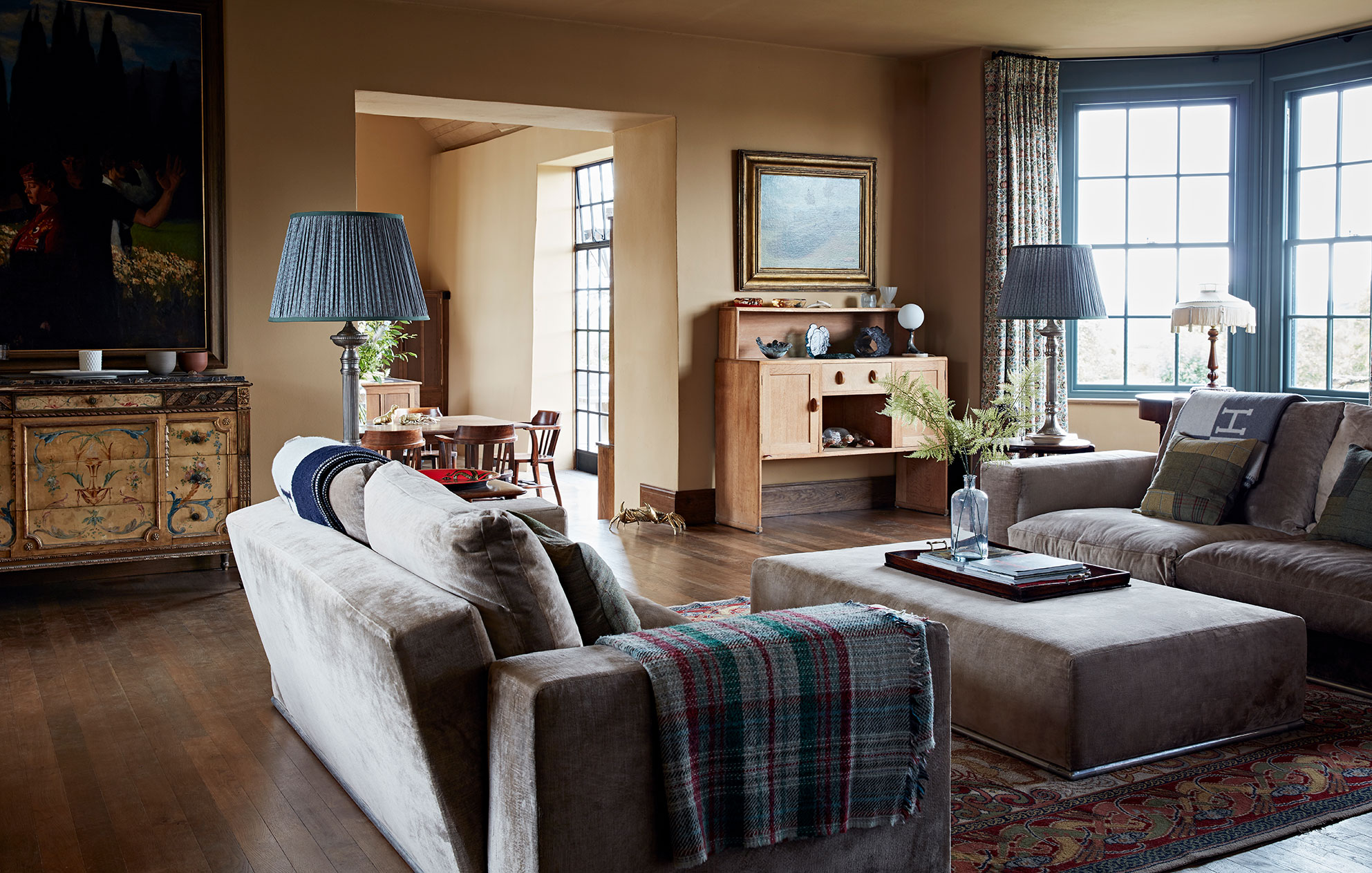 Soft natural colours of lime walls and wooden floors in a stunning rural home living room by Godrich Interiors.