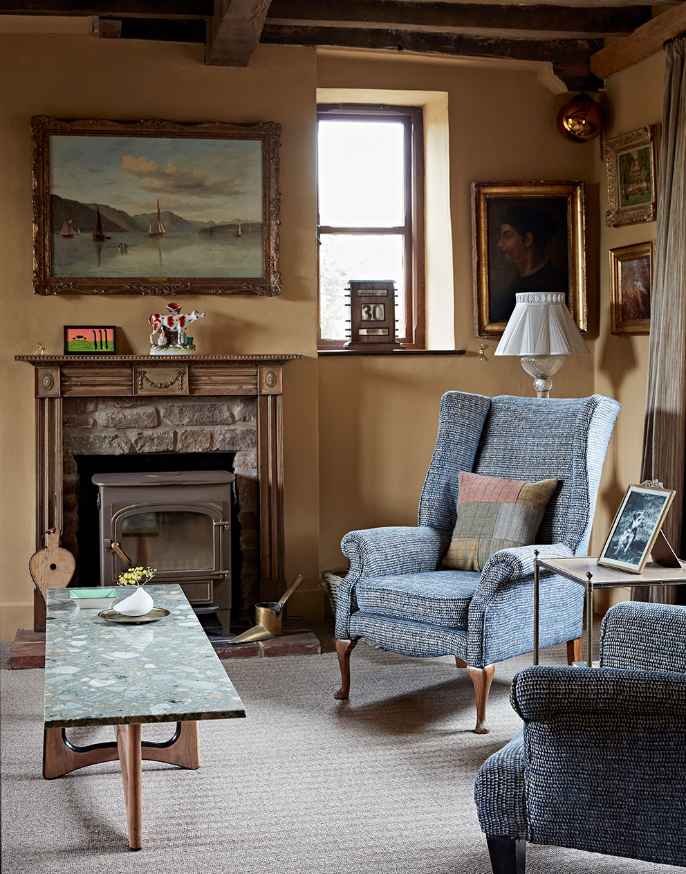 Comfortable upholstered armchairs around a mid-century modern marble coffee table in this luxury rural home designed by Godrich.