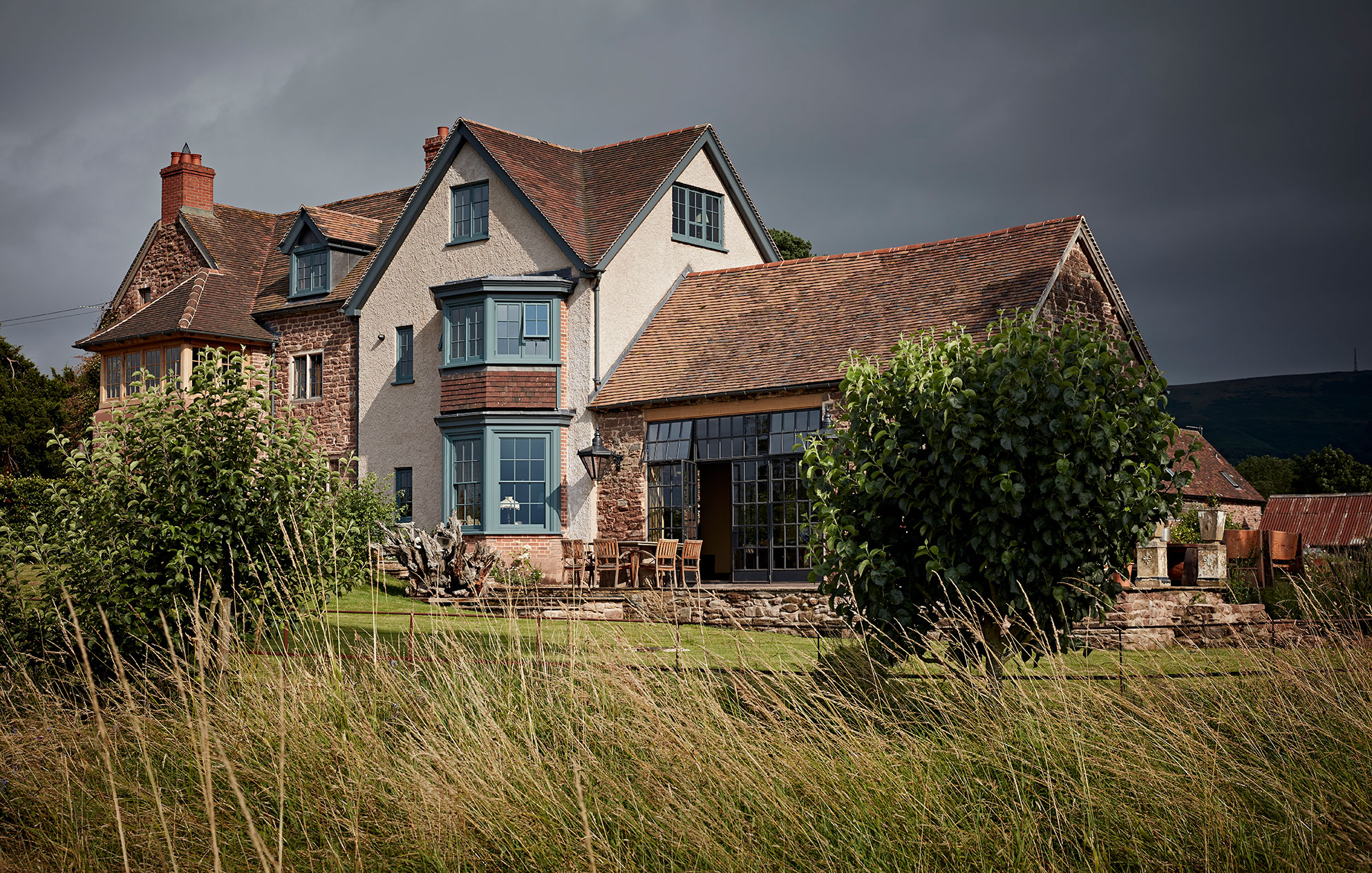 Exterior shot of this inviting rural home whose outbuildings were sensitively converted and designed by Godrich Interiors.