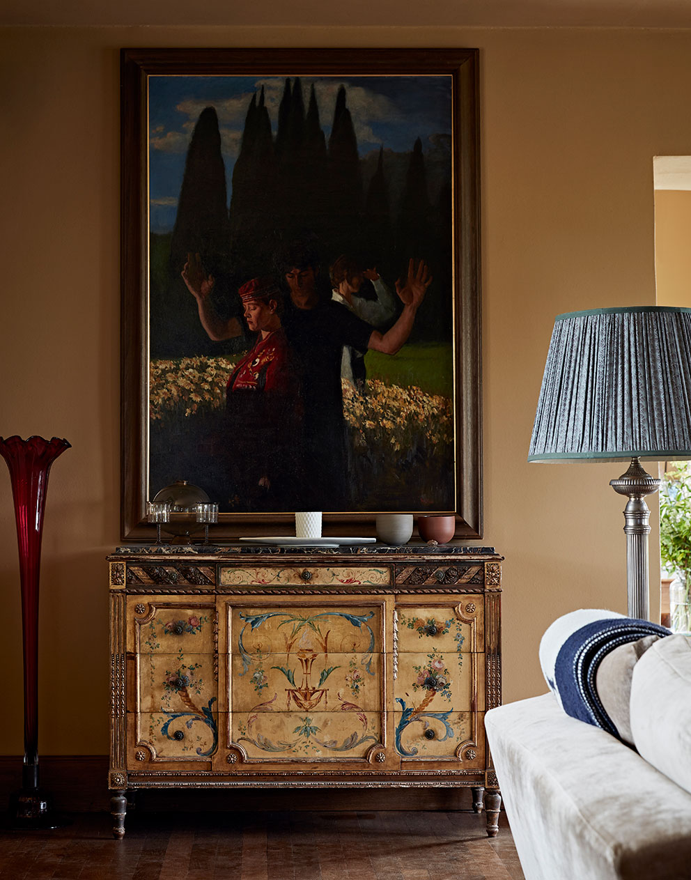 Antique furniture and a unique painting on the lime walls of a rural home with bespoke interior design by Godrich.