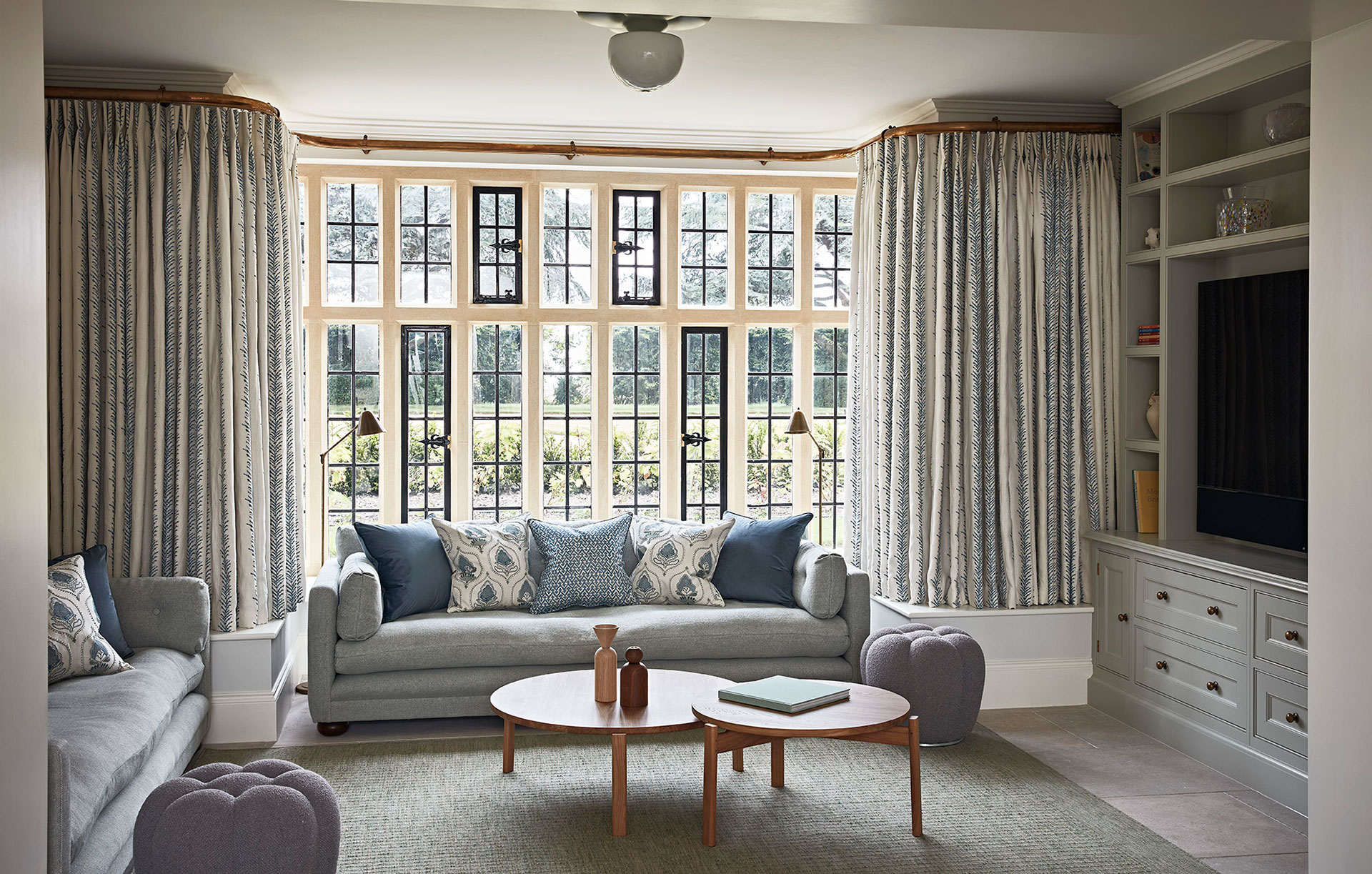 Luxury living room design in a Hampshire Manor House in muted greys with coordinated soft furnishings on the grey sofa.