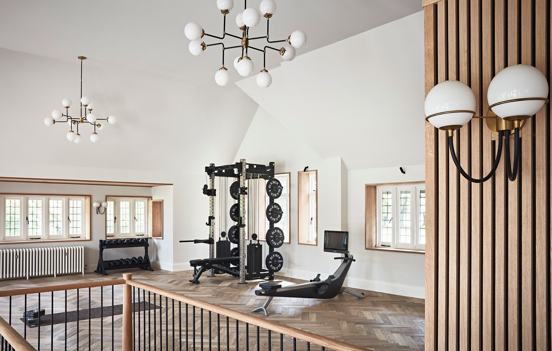 Light and airy gym with parquet floors and modernist chandeliers in a Hampshire manor house.
