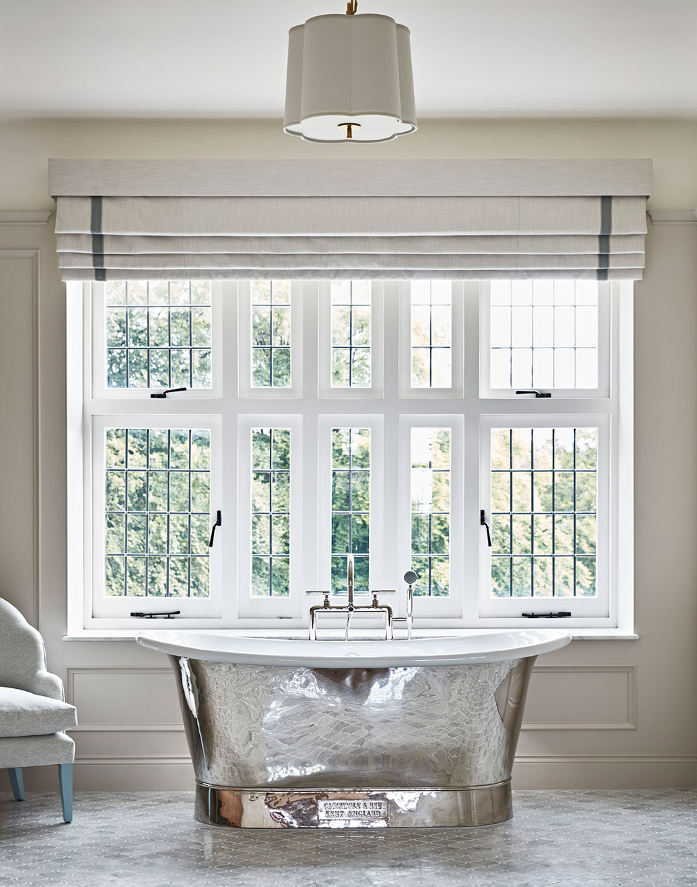 Stunning bathroom with a highly polished bath set against leaded windows in a country manor house in Hampshire.