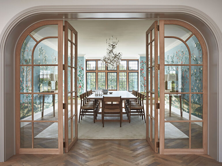 Stunning luxury dining room in a manor house with colourful walls, wooden parquet floor and glass chandelier.